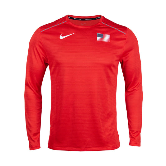 A long-sleeved red Nike Miler top with a V-neck, featuring a reflective Swoosh logo on the chest and a Nike logo on the upper left. The shirt is made of polyester and is machine washable.